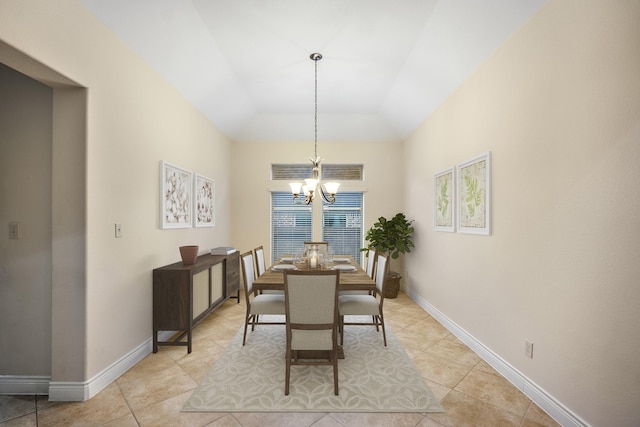 dining room with a raised ceiling, light tile patterned floors, and a notable chandelier