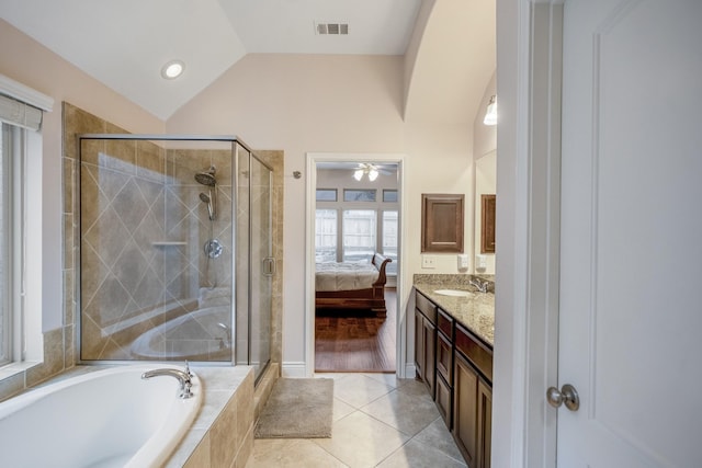 bathroom featuring tile patterned flooring, vanity, vaulted ceiling, and plus walk in shower