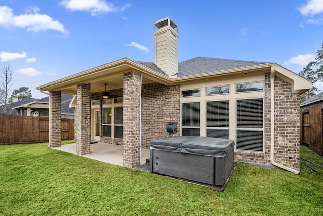 back of house with a patio area, a hot tub, ceiling fan, and a lawn