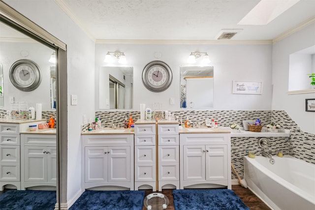 bathroom with vanity, a washtub, crown molding, and tasteful backsplash