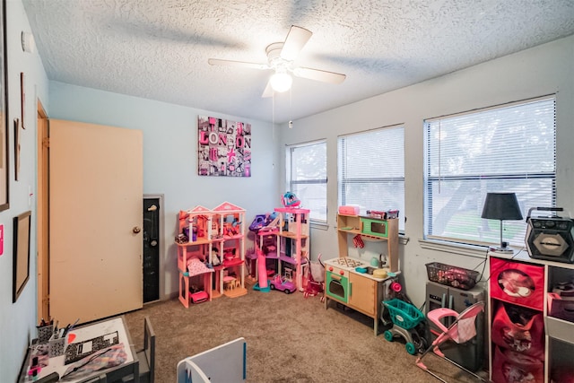 rec room featuring carpet, a textured ceiling, and ceiling fan