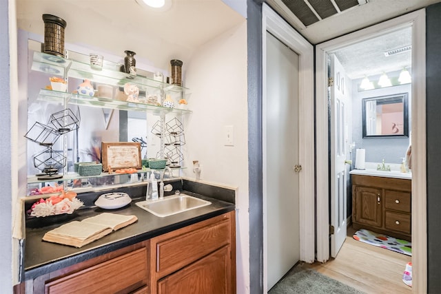 bar featuring sink and light hardwood / wood-style floors