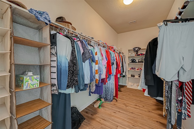 walk in closet with light hardwood / wood-style flooring