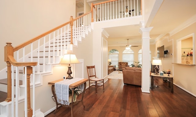 interior space with ornate columns, ornamental molding, hardwood / wood-style floors, and ceiling fan