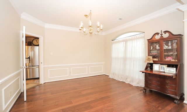 unfurnished room with crown molding, dark hardwood / wood-style floors, and an inviting chandelier