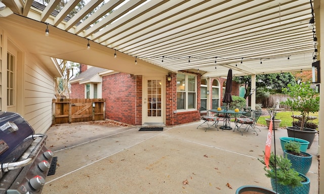 view of patio with area for grilling and a pergola