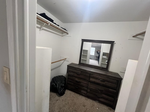 walk in closet featuring light colored carpet