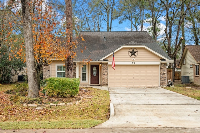 view of front of house with a garage and central air condition unit