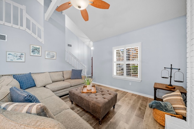 living room featuring beamed ceiling, ceiling fan, high vaulted ceiling, and hardwood / wood-style floors