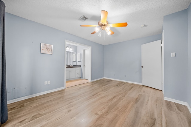 interior space with ceiling fan, a textured ceiling, and light wood-type flooring