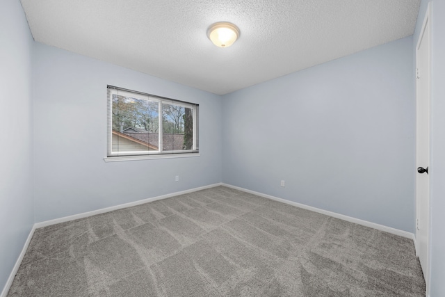 spare room featuring light carpet and a textured ceiling