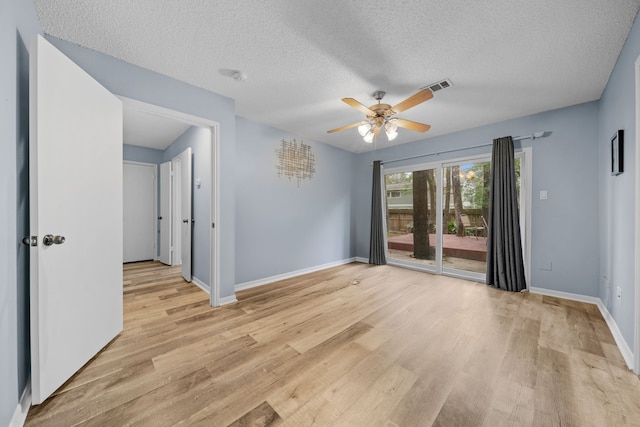 empty room featuring ceiling fan, light hardwood / wood-style floors, and a textured ceiling