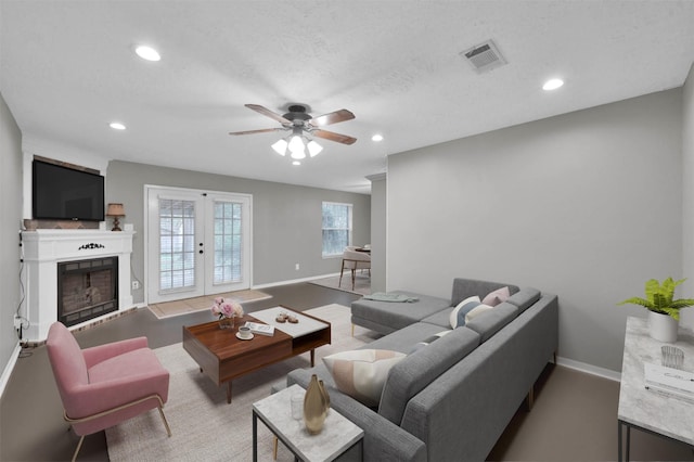 living room featuring ceiling fan and a textured ceiling