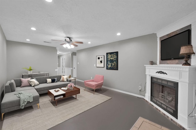 living room with ceiling fan and a textured ceiling