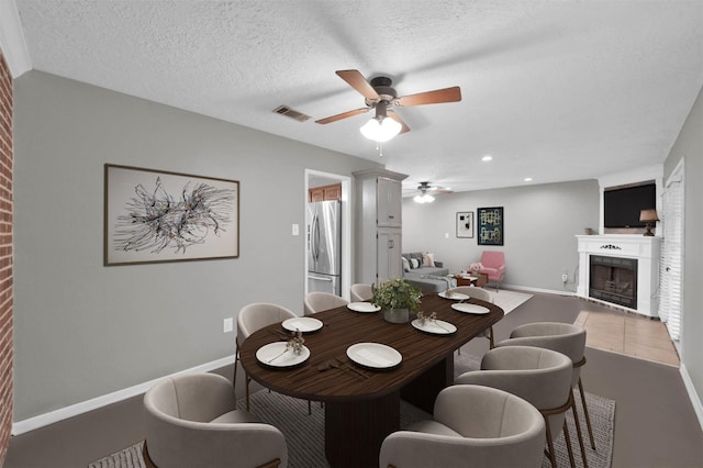 dining area featuring ceiling fan and a textured ceiling