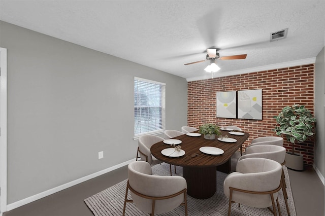 dining space featuring ceiling fan, brick wall, and a textured ceiling