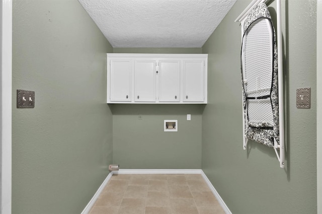 laundry room featuring washer hookup, cabinets, and a textured ceiling