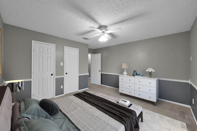 bedroom with carpet floors, a textured ceiling, and ceiling fan