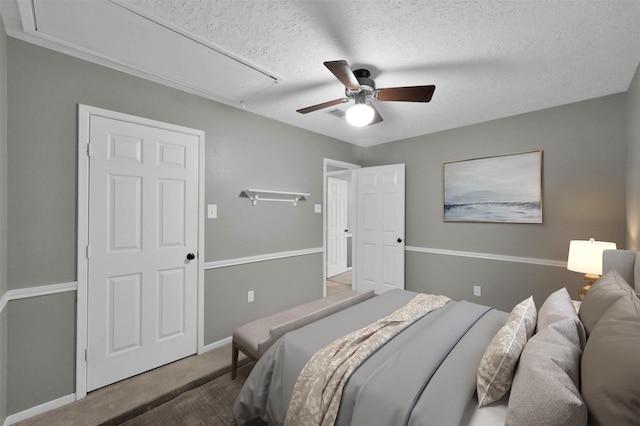 carpeted bedroom featuring a textured ceiling and ceiling fan