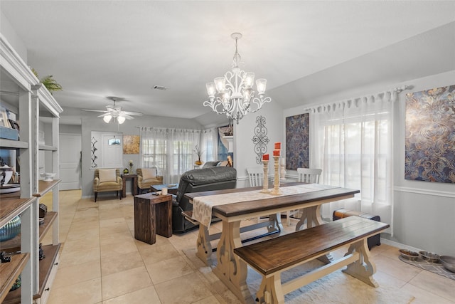 dining space with lofted ceiling, light tile patterned floors, and ceiling fan with notable chandelier