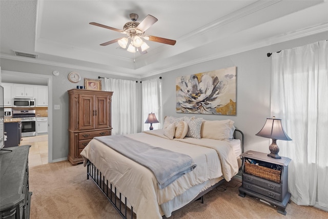 bedroom with light carpet, a tray ceiling, ornamental molding, and ceiling fan