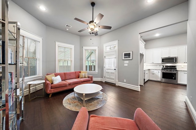 living room featuring ceiling fan, a wealth of natural light, and dark hardwood / wood-style flooring