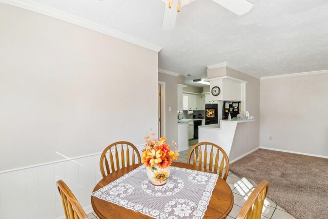 dining room with ornamental molding, light colored carpet, and ceiling fan