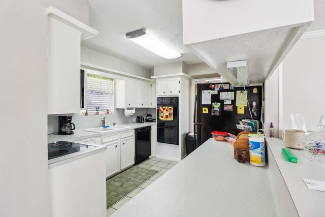 kitchen featuring white cabinetry, light tile patterned floors, sink, and black appliances