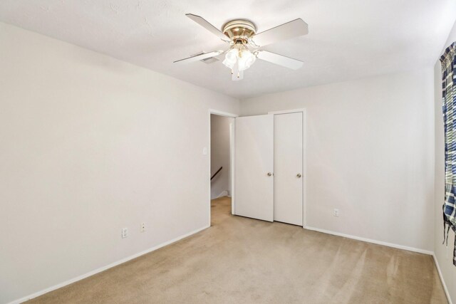 unfurnished bedroom featuring light carpet and ceiling fan