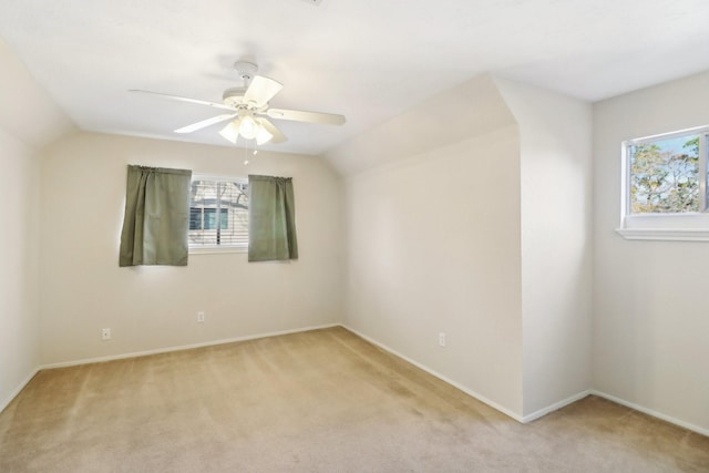 spare room with plenty of natural light, light colored carpet, lofted ceiling, and ceiling fan