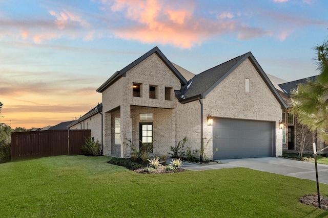 french provincial home featuring a garage and a lawn