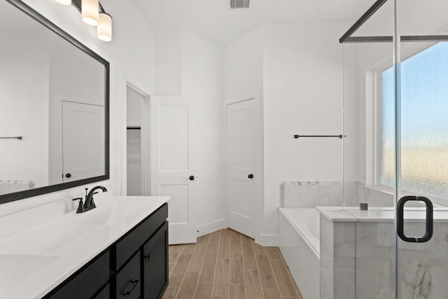 bathroom featuring vanity, a wealth of natural light, and separate shower and tub