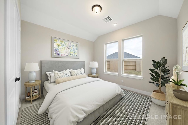 carpeted bedroom with visible vents, vaulted ceiling, and baseboards