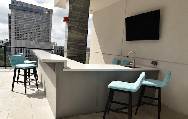 bar with a wall of windows, sink, and light tile patterned floors