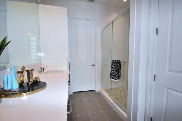 bathroom with tile patterned floors, a shower with door, and vanity