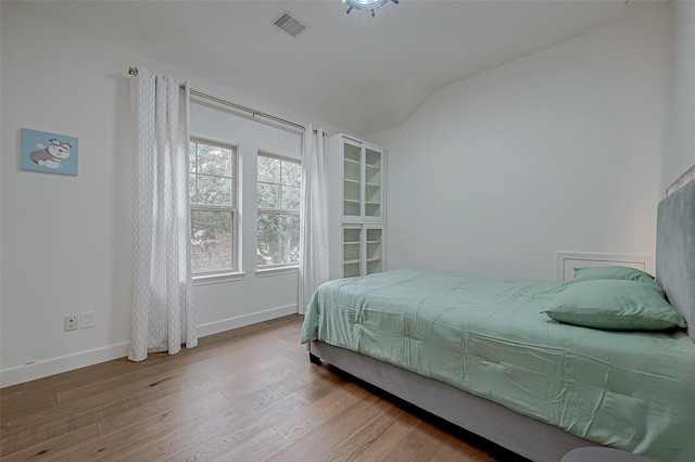 bedroom featuring vaulted ceiling and light hardwood / wood-style flooring