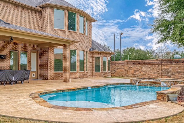 view of swimming pool featuring a patio area, pool water feature, ceiling fan, and an in ground hot tub