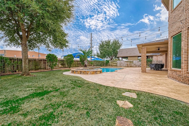 view of yard featuring a swimming pool with hot tub, ceiling fan, and a patio area