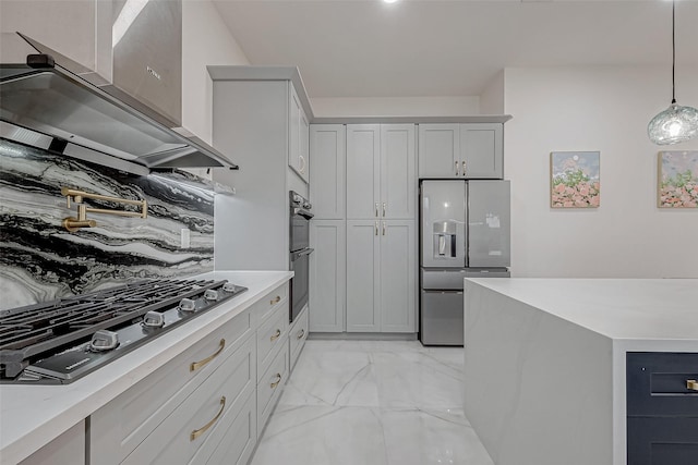 kitchen with wall chimney range hood, gray cabinets, hanging light fixtures, stainless steel appliances, and tasteful backsplash