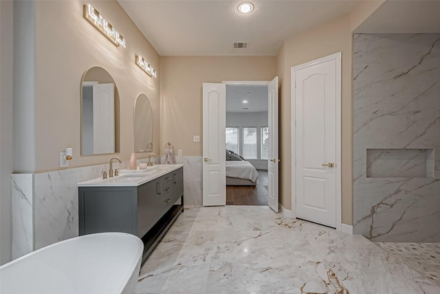 bathroom featuring vanity and a washtub