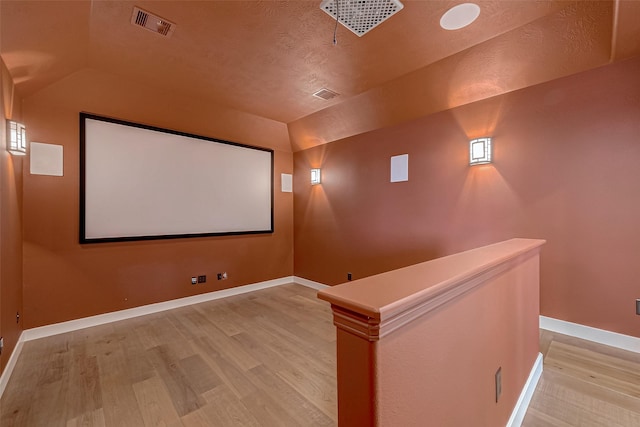 home theater with light hardwood / wood-style floors and a textured ceiling