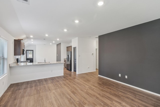 unfurnished living room with light hardwood / wood-style floors and sink