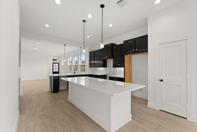 kitchen featuring pendant lighting, a center island, and sink