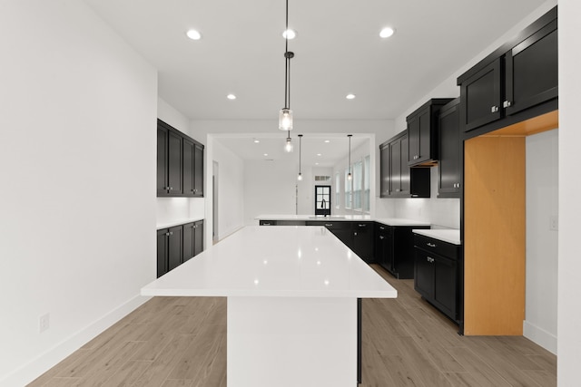 kitchen featuring hanging light fixtures, a center island, sink, and kitchen peninsula