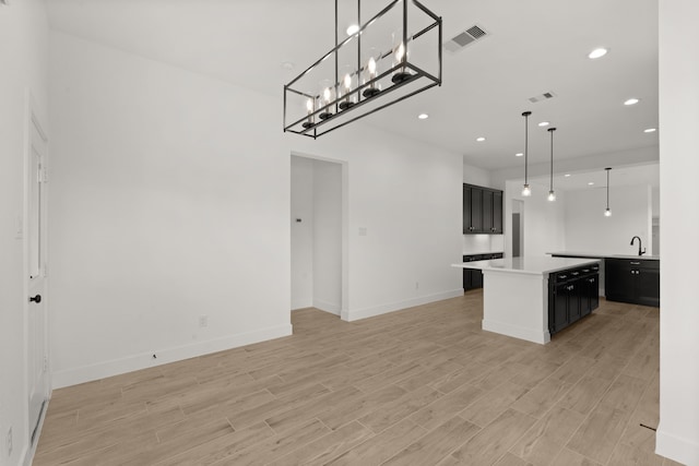 kitchen featuring sink, decorative light fixtures, and a center island