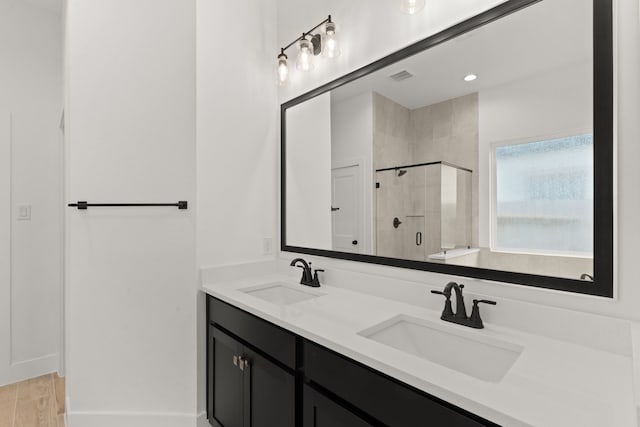 bathroom with vanity, a shower with door, and hardwood / wood-style floors