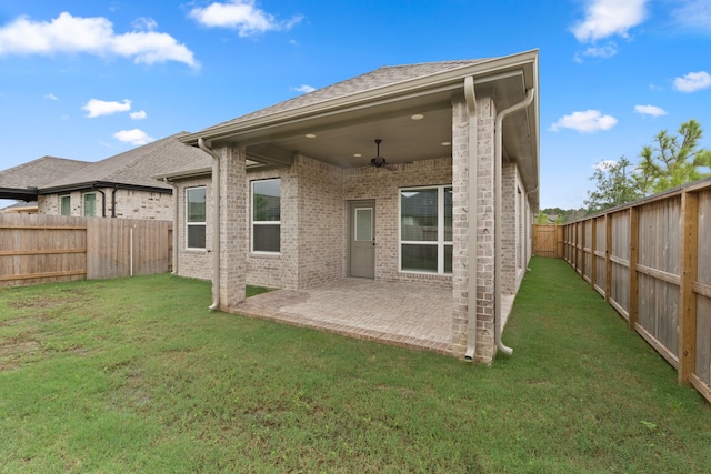 back of property featuring ceiling fan, a yard, and a patio