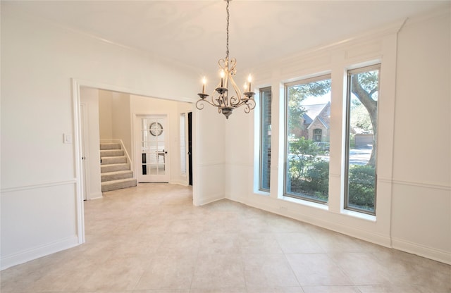 unfurnished room with crown molding and a chandelier