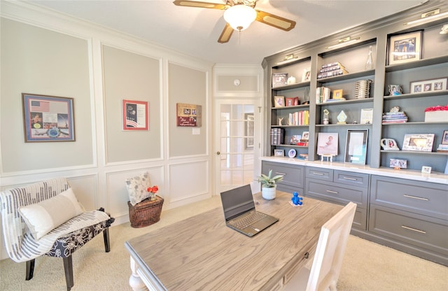 office area with ornamental molding, light carpet, and ceiling fan