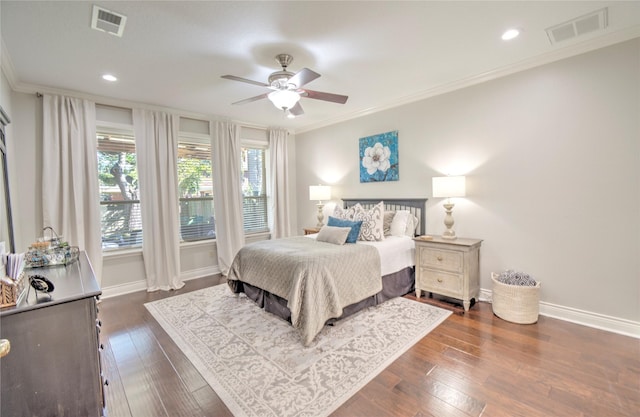 bedroom with crown molding, dark hardwood / wood-style flooring, and ceiling fan